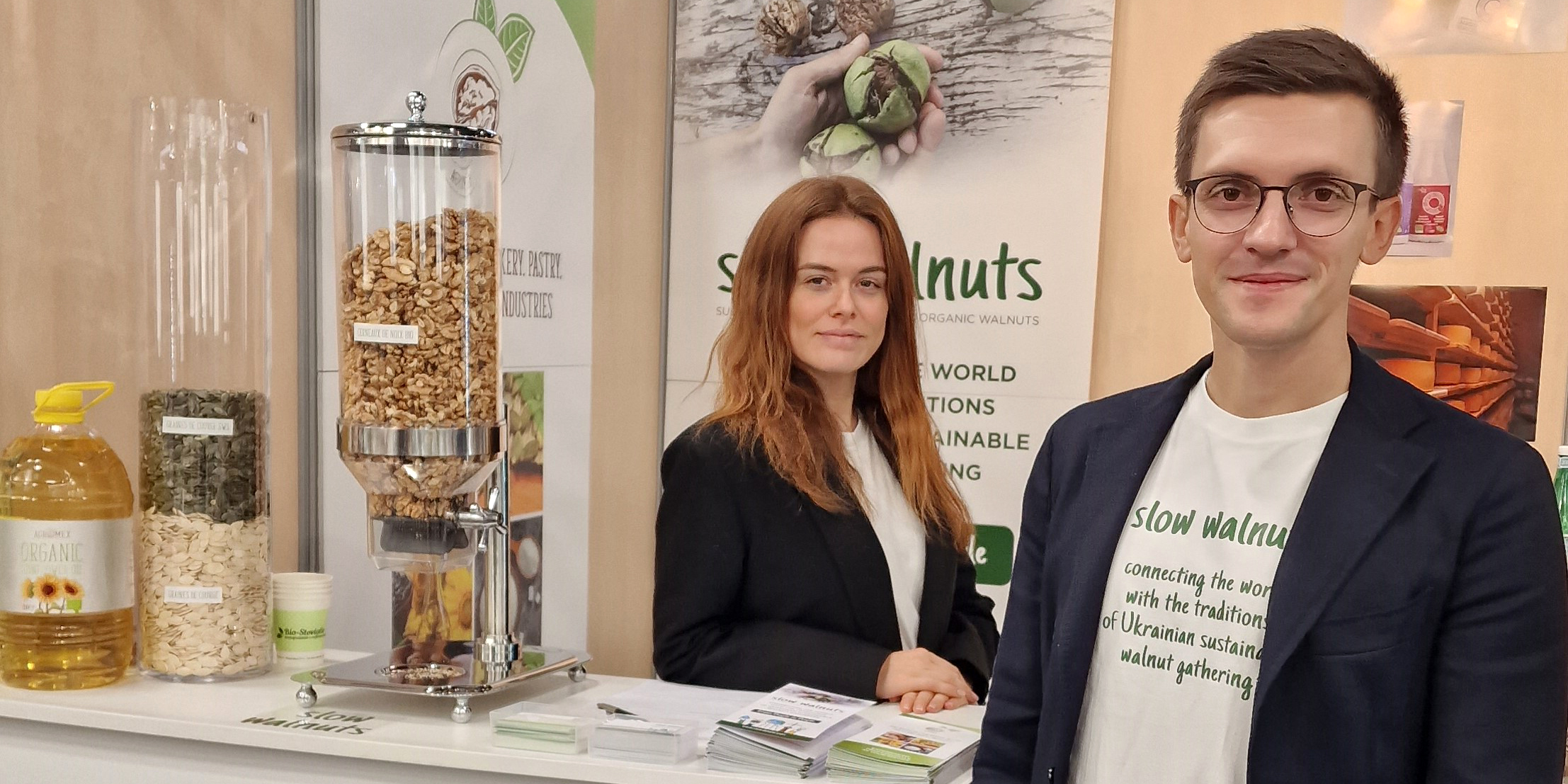 Man and woman standing at an exhibition stand with walnuts