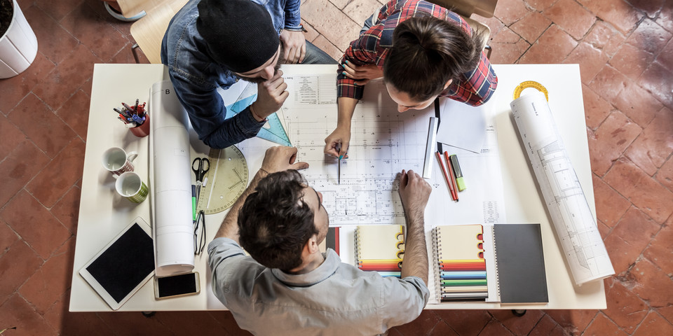 people working at sketch table 