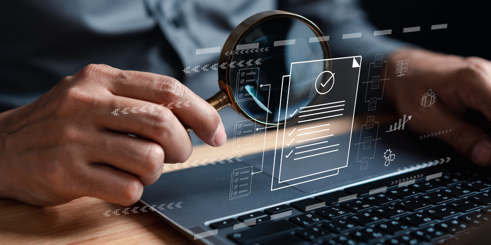 hand holds magnifier in front of computer